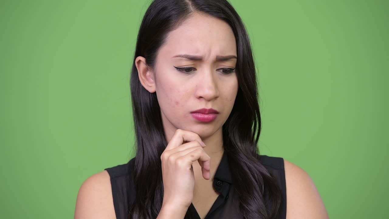 젊은 아름다운 아시아 사업가 여성이 생각하고 있습니다.