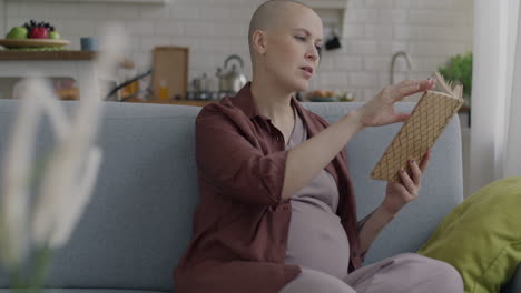 pregnant woman reading a book at home