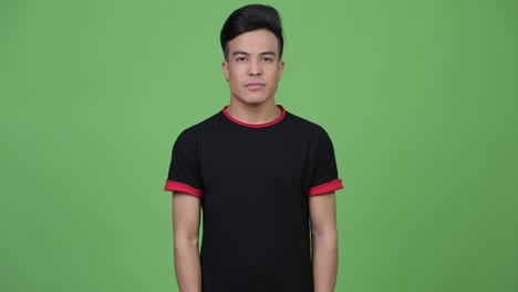 young happy multi-ethnic man smiling with arms crossed