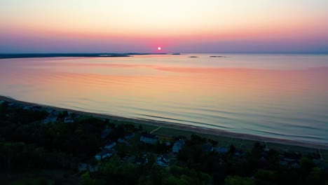 sunrise over beach houses with colorful reflections off ocean waves and vacation homes along the new england atlantic coastline