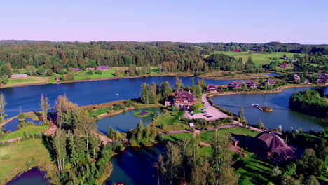 Aerial-drone-backward-moving-shot-over-beautiful-lakeside-village-of-Amatciems-in-Latvia