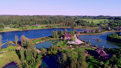 Un-Dron-Aéreo-Se-Disparó-Hacia-Atrás-Sobre-El-Hermoso-Pueblo-De-Amatciems,-Junto-Al-Lago,-En-Letonia.