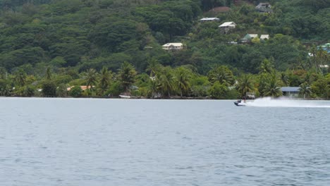 jet ski ride in raiatea, society islands, french polynesia. houses by the shore.