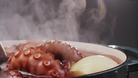 octopus cooking, chef boiling fresh octopus on restaurant kitchen, healthy food, seafood cafe in spain, traditional asian japanese spanish and mediterranean dish.