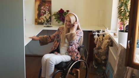 A-cute-fair-haired-girl-in-a-wheelchair,-wearing-headphones,-dances-and-sings