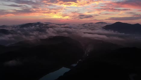 a drone flying over the clouds at dawn