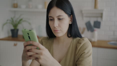 mujer usando un teléfono inteligente en la cocina