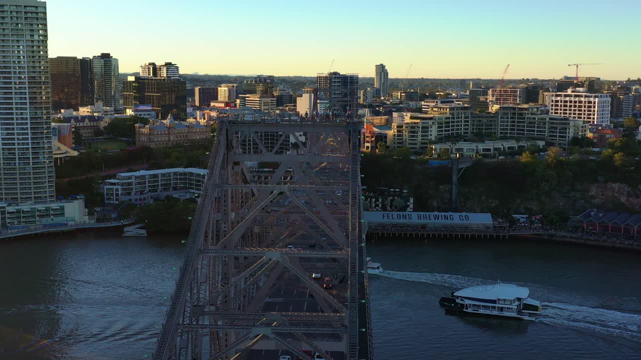Sunset golden hours, aerial shot capturing iconic landmark Story bridge, busy traffics crossing the Brisbane river between Fortitude valley and Kangaroo point inner city suburbs