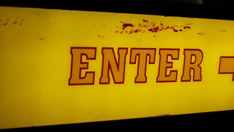 Pan-Across-Old-School-Retro-Light-Up-Enter-Sign-with-an-Arrow-Night