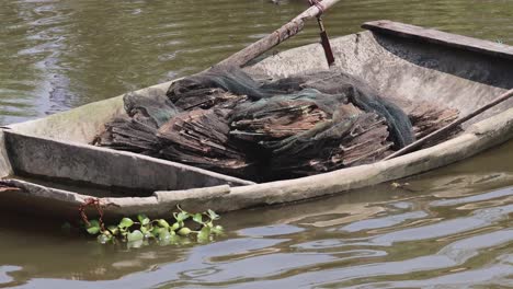 a weathered boat floats gently on a river