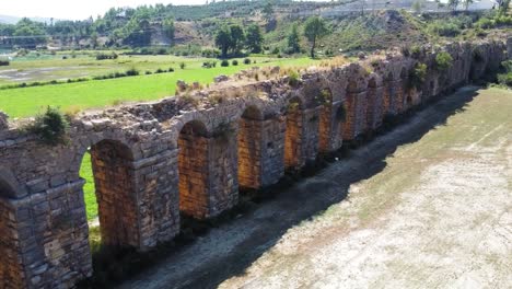 Panorámica-Lenta-Del-Lado-De-La-Sombra-Del-Antiguo-Acueducto-Durante-El-Día-Soleado-En-El-Lado,-Turquía