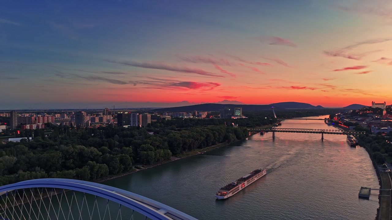 Solnedgang over Donau-floden i Bratislava, Slovakiet med en båd