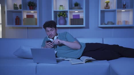 Hombre-Usando-Las-Redes-Sociales-Por-Teléfono-Riéndose-De-La-Noche-En-Casa.