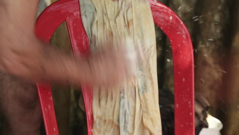 close-up of elderly man's hands washing laundry with soap in capurgana, colombia