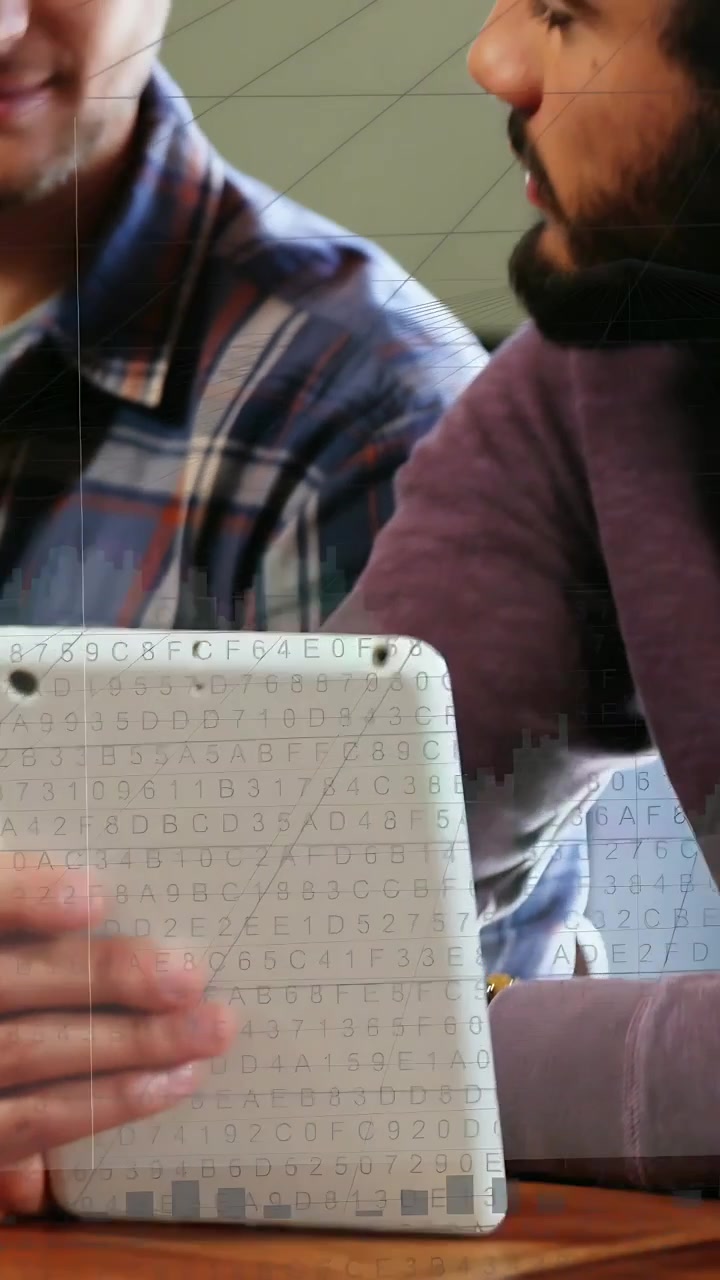 Video vertical: Dos hombres inclinándose, inclinando una tableta y mostrando gráficos de TI, código en los torsos para revisión.