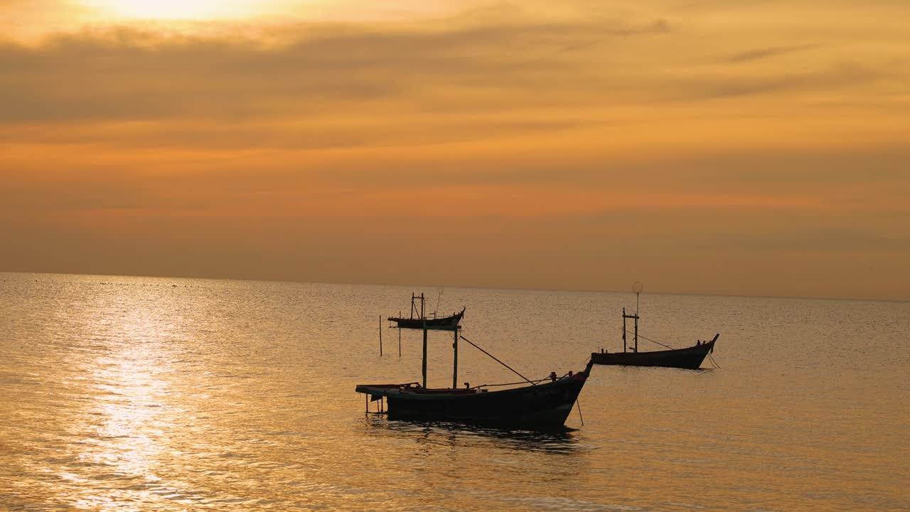 Boats gently float on a golden sea