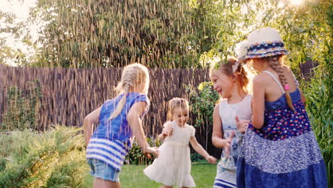 children play in garden under streams of water