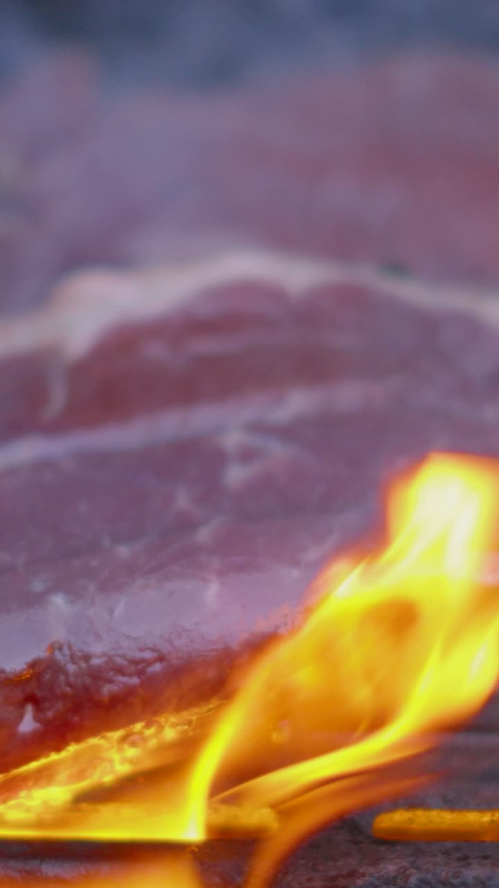 Bistecche succulente cotte alla fiamma su un barbecue rovente. Filmato di alta qualità, perfetto per documentari di cucina e contenuti lifestyle estivi per i social media. Video verticale in formato 9:16.