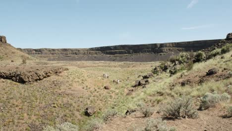 Hikers-enjoy-dry-grass-basin-below-Dry-Falls-in-Washington-Scablands