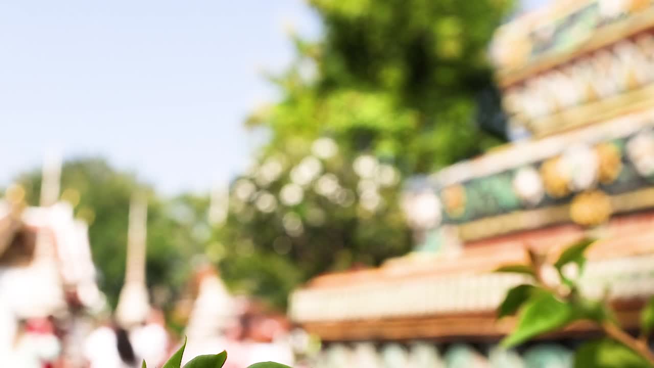 A vibrant pagoda surrounded by lush green foliage under clear blue skies, capturing a serene outdoor scene.