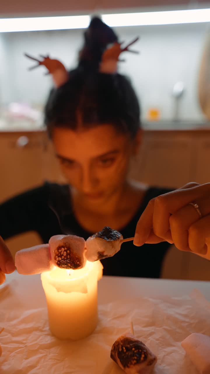 Woman toasting marshmallows over a candle