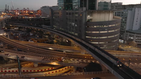 mtr subway train drives over elevated track while buses and cars driving over a highway