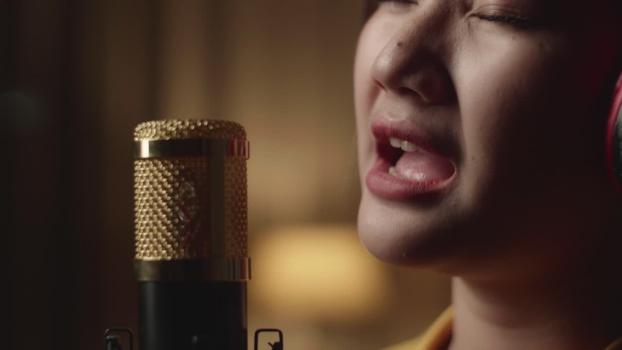 mujer cantando en el micrófono en el estudio de grabación