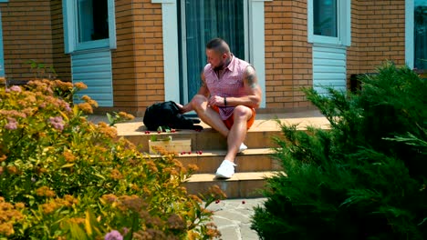 young man with black dog sitting on the house porch