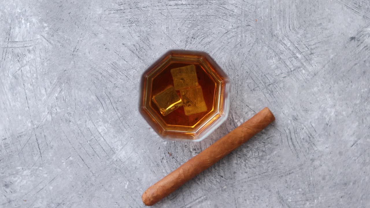 whisky o brandy en un vaso con cigarro cubano