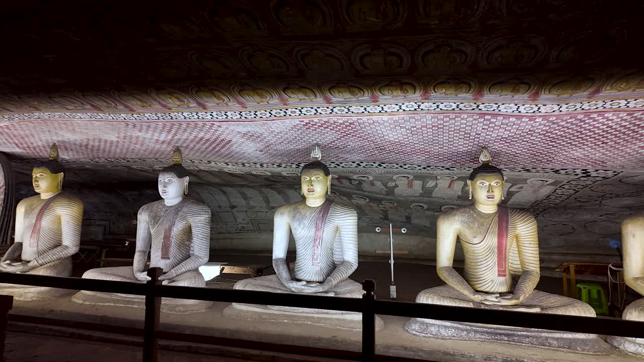 Several golden buddha statues are meditating inside the dambulla cave temple, a unesco world heritage site in sri lanka