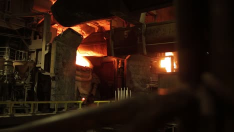 Fiery-molten-metal-pouring-in-an-industrial-foundry,-captured-in-vivid-detail-against-dark-surroundings