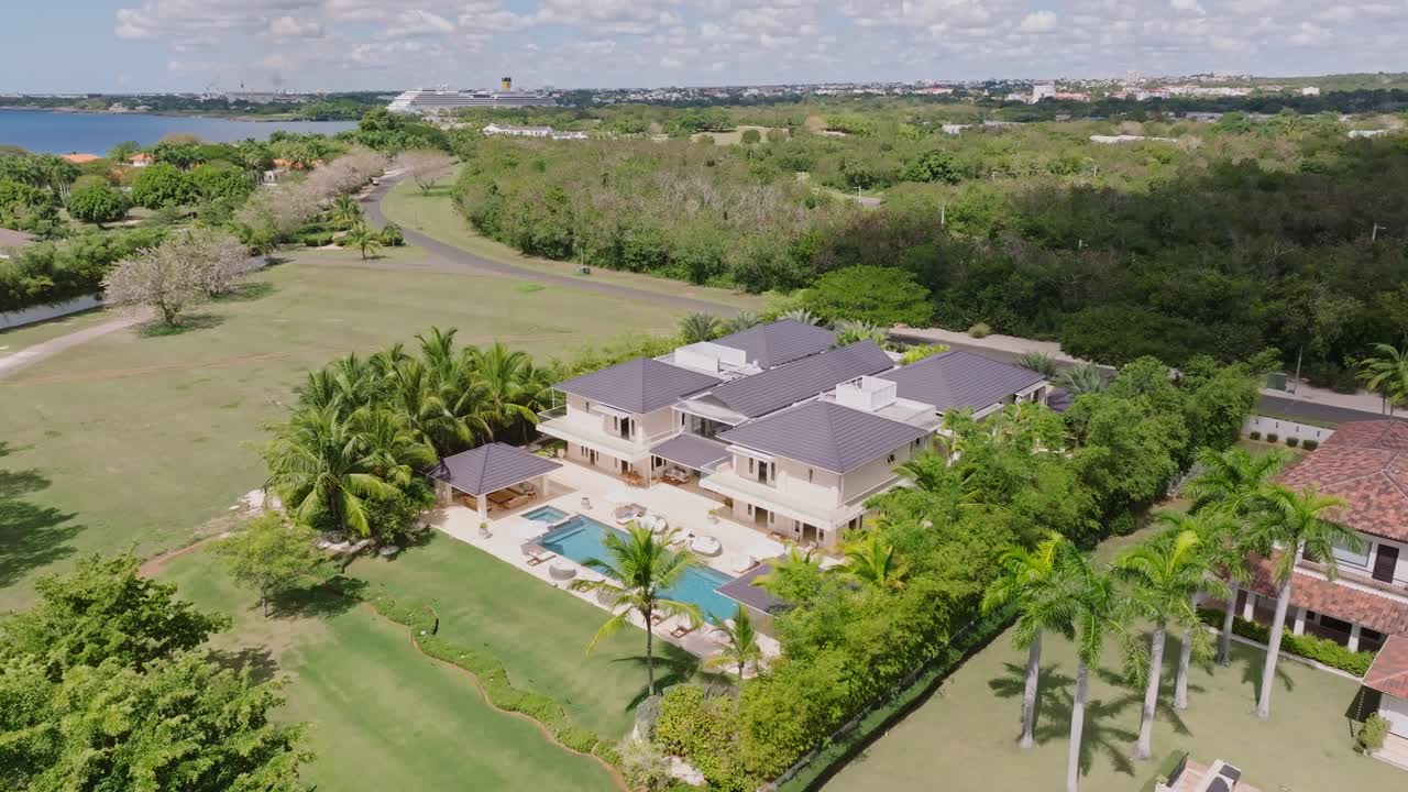 Upper class villa with private pool and Caribbean sea in background.Aerial Orbit shot. Luxury mansion on Dominican Republic.