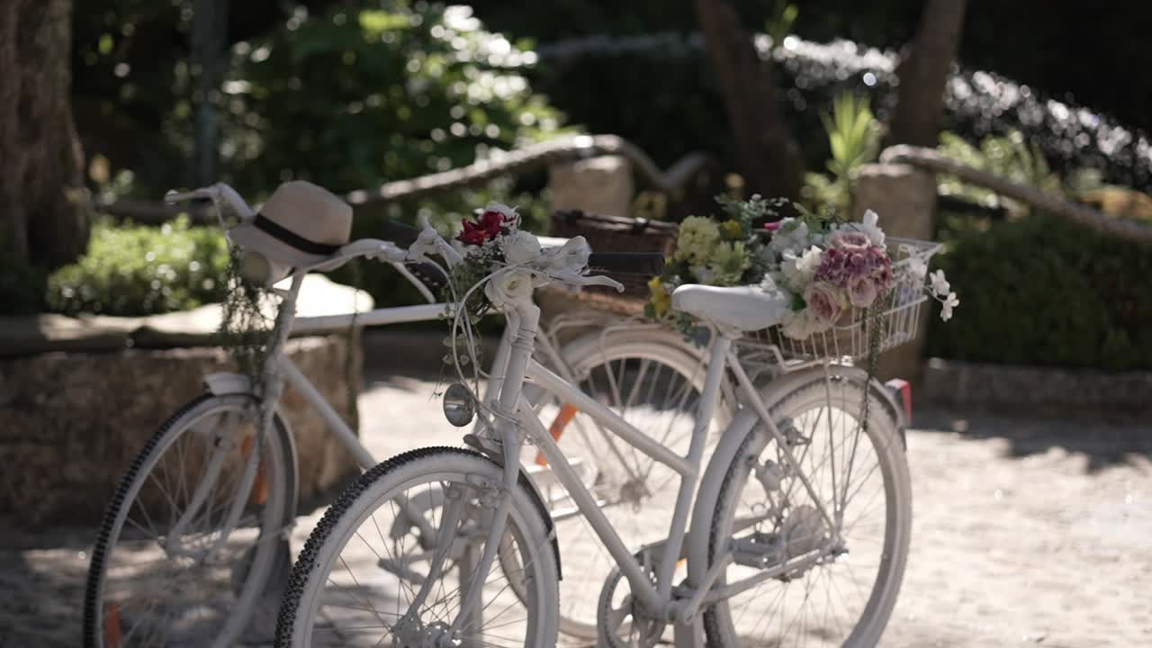 romantic white bicycles adorned with flowers in sunny rustic garden