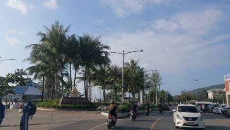 driving through a lively street in koh samui, thailand, with motorbikes and cars passing by
