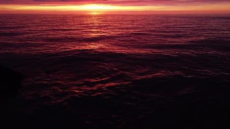 Beautiful-aerial-vibrant-high-contrast-pink-purple-sunset-over-Baltic-sea,-Karosta-war-port-concrete-coast-fortification-ruins-at-Liepaja,-wide-angle-drone-shot-moving-forward,-camera-tilt-up