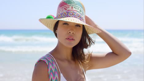 Smiling-young-woman-holding-her-sunhat