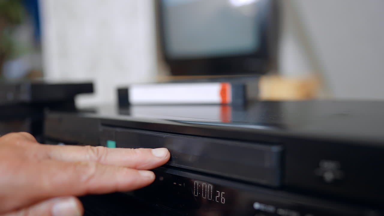 Vintage VCR with tape on top. A close view of an old VCR player with a VHS cassette resting on its surface