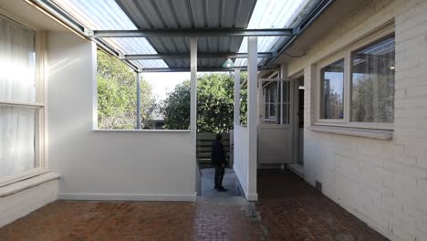 man walking into frame and talking to someone out of frame before continuing up upstairs