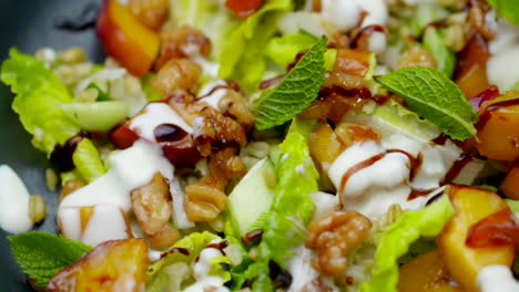 Plato-De-Almuerzo-Saludable-Con-Ensalada,-Nectarina-Y-Nueces-Girando-En-Primer-Plano