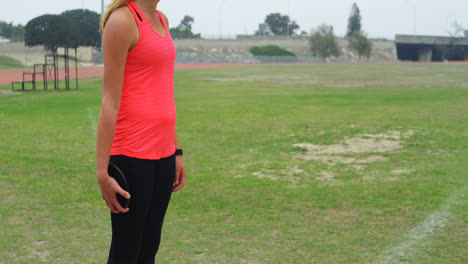 Side-view-of-Caucasian-female-athlete-getting-ready-for-discus-throw-at-sports-venue-4k