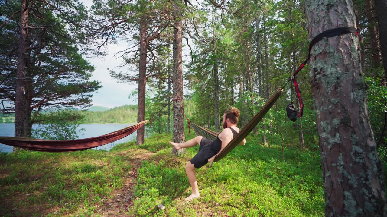 hombre con hamaca relajándose en el bosque