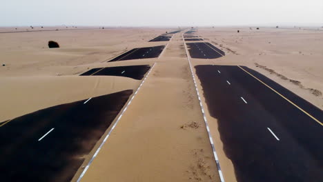 Aerial-view-of-abandoned-post-apocalyptic-roads-covered-in-sand-dunes