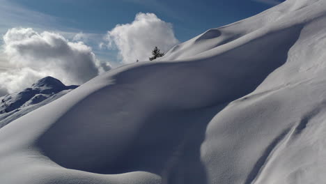 drone shot dollying forward and up towards snow formations to reveal beautiful mountain side covered in fresh snow, in la plagne france