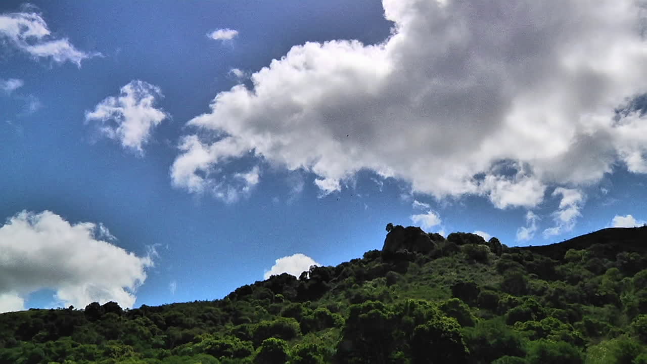 녹색 산비탈을 통과하는 구름의 시간 경과