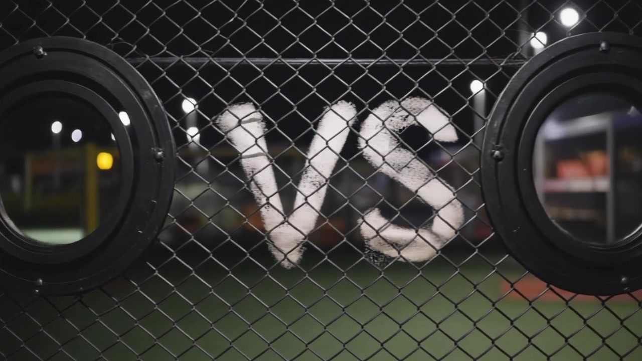 Camera Panning Across Chain Link Fence with VS Graffiti and Circular Windows