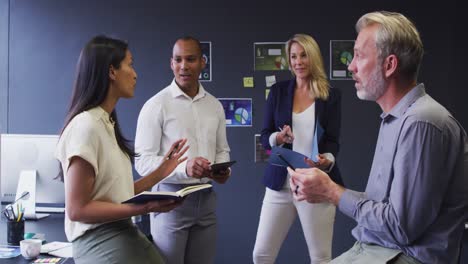diverse business people standing and talking in casual office meeting