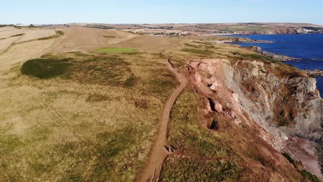 aerial view of path next to cliffside on coast of village