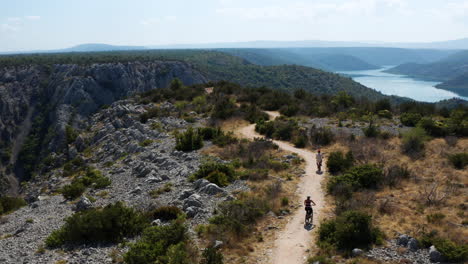 ciclistas conduciendo hacia el mirador en el pintoresco parque nacional krka, croacia - toma aérea de drones