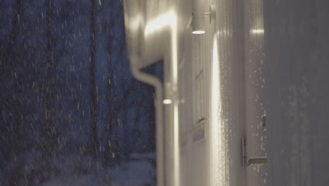 on a snowy night, man quickly grabs door handle to go inside