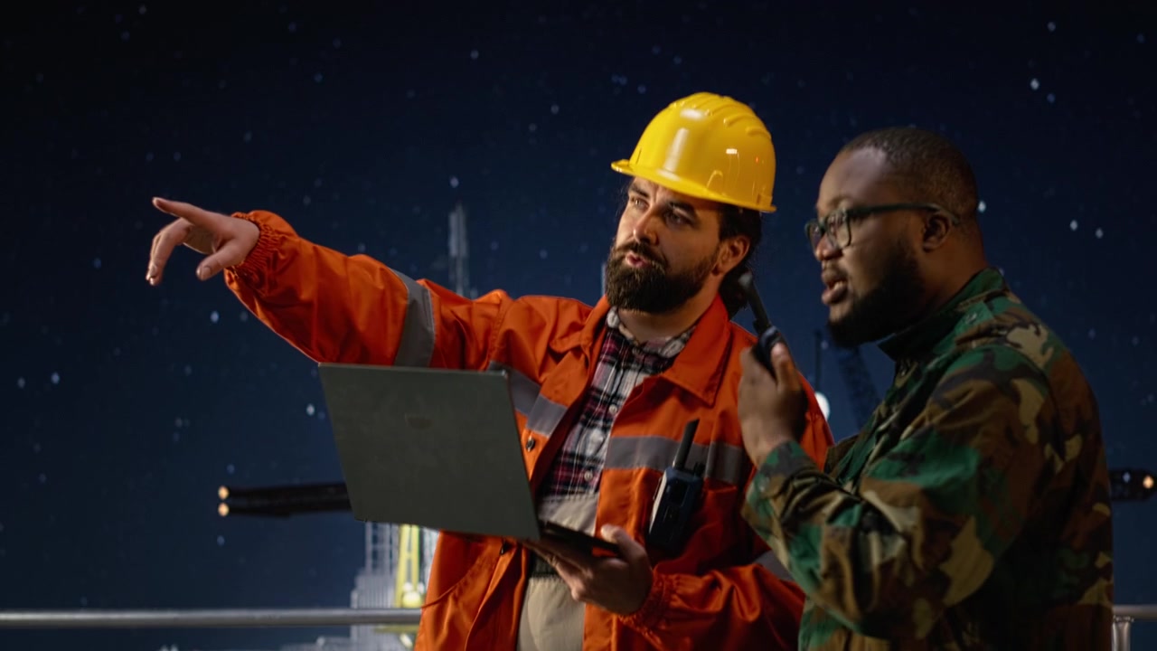 Military man on drilling rig speaks into walkie talkie, enforcing blockade
